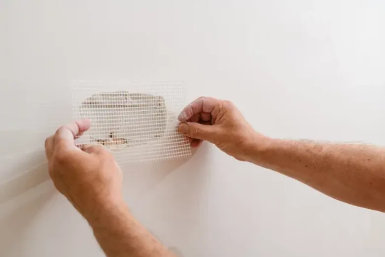 guy repairing hole in drywall